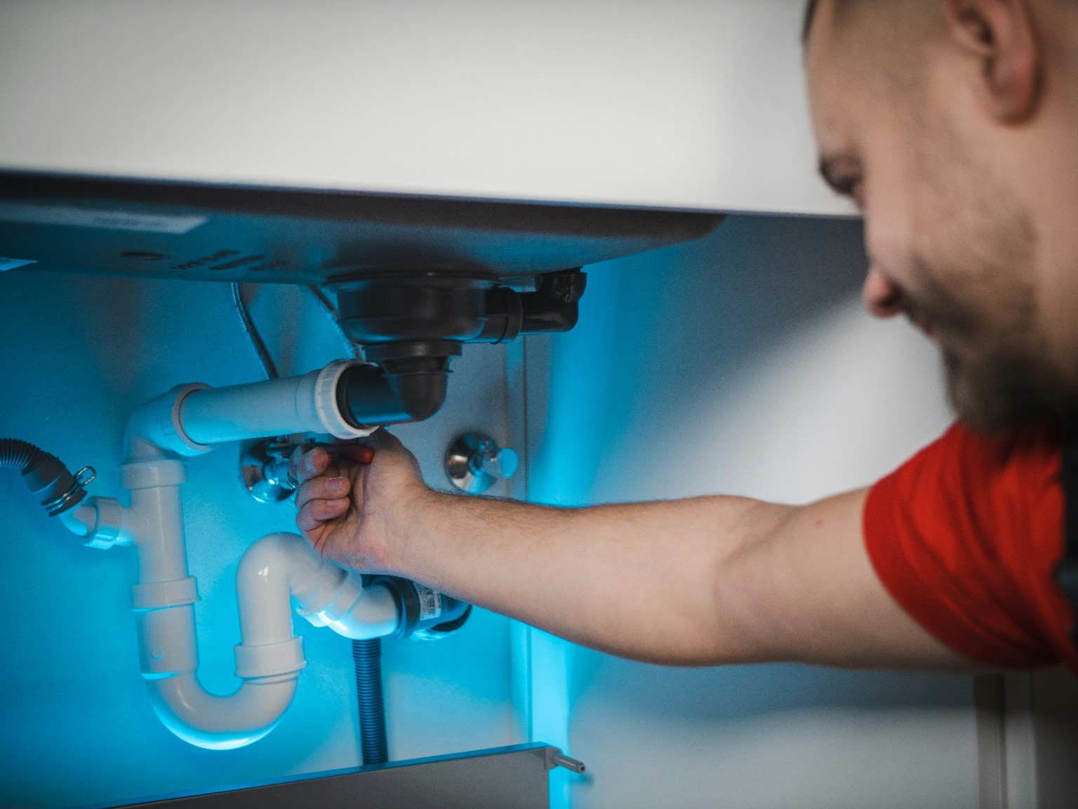 Plumber working under a sink